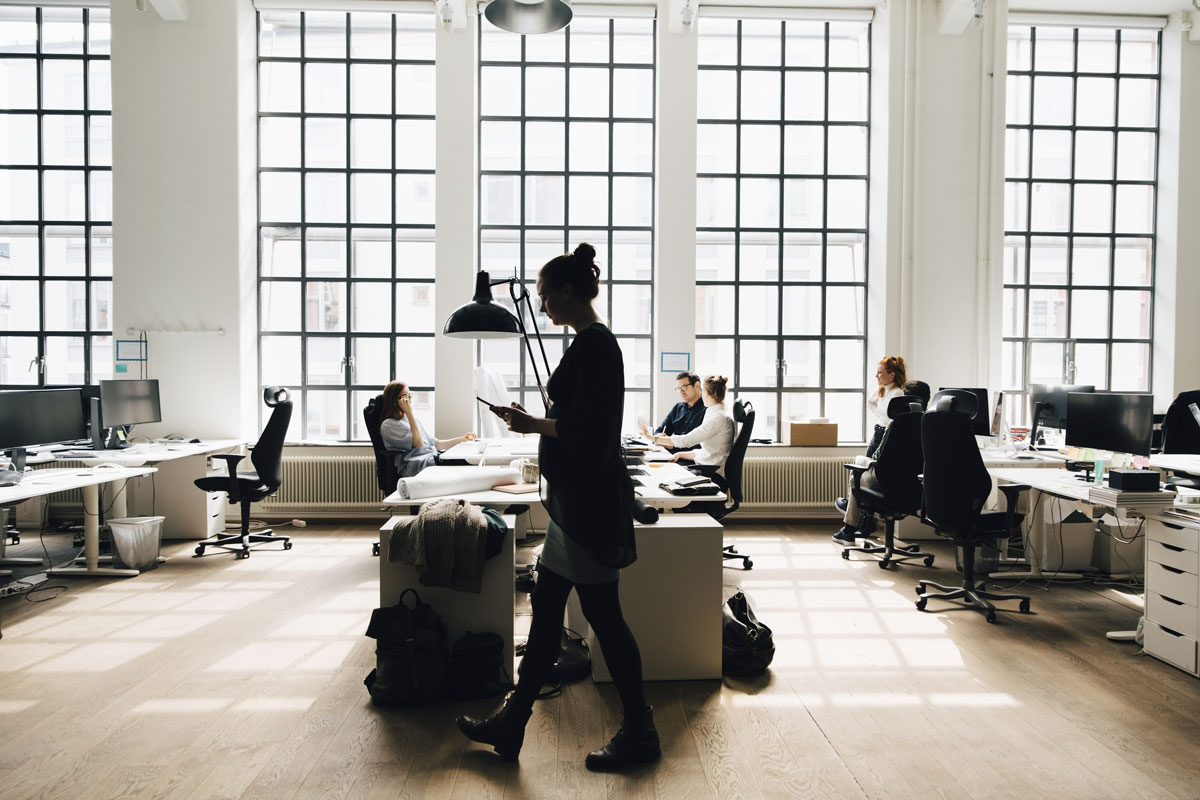 Male and female business colleagues working against window in office